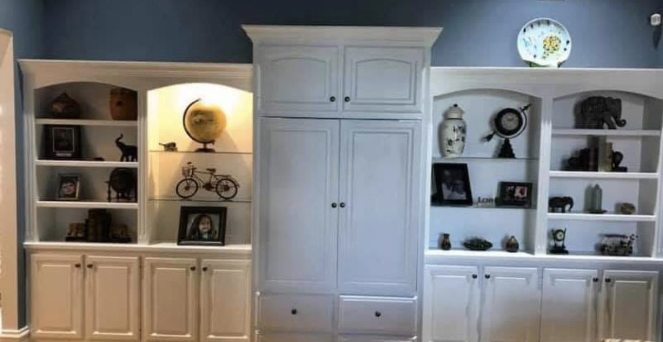 White painted built-in shelving against a deep blue wall