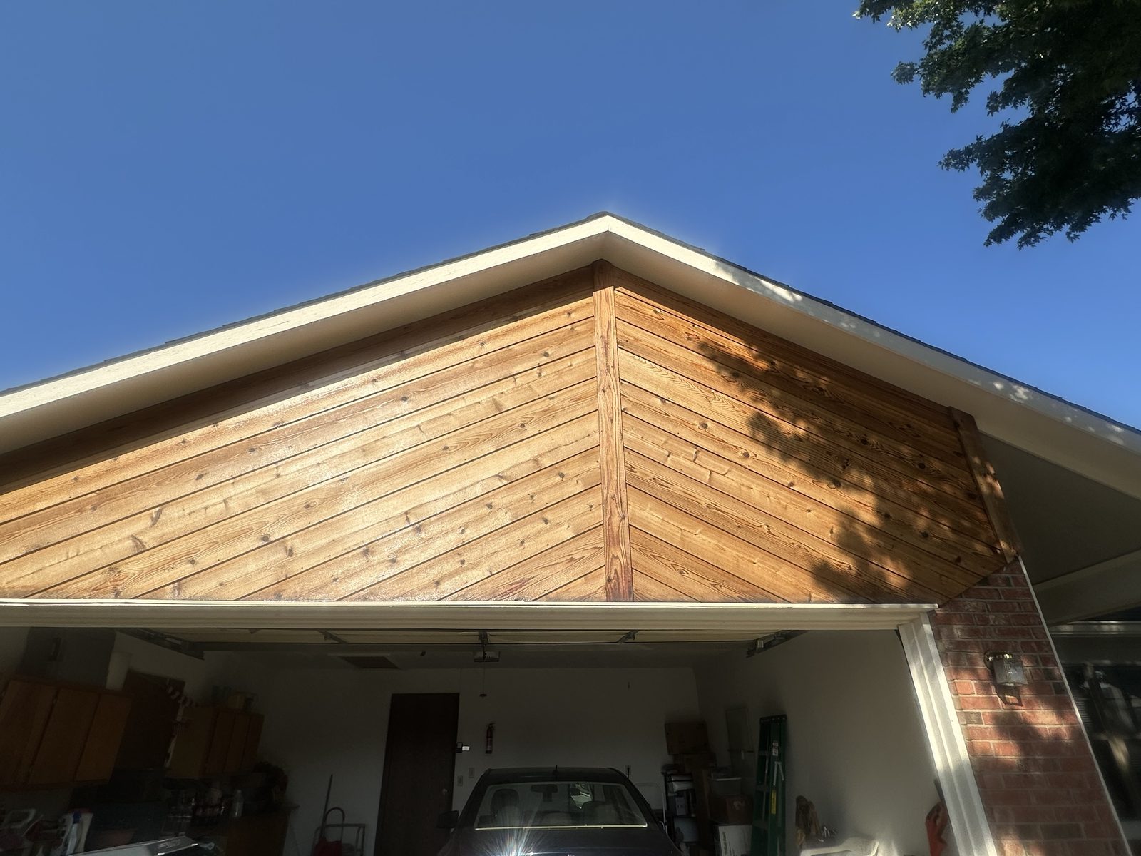 A cedar gable peak above a garage, sealed with clear coat so the natural grain and warm tone show
